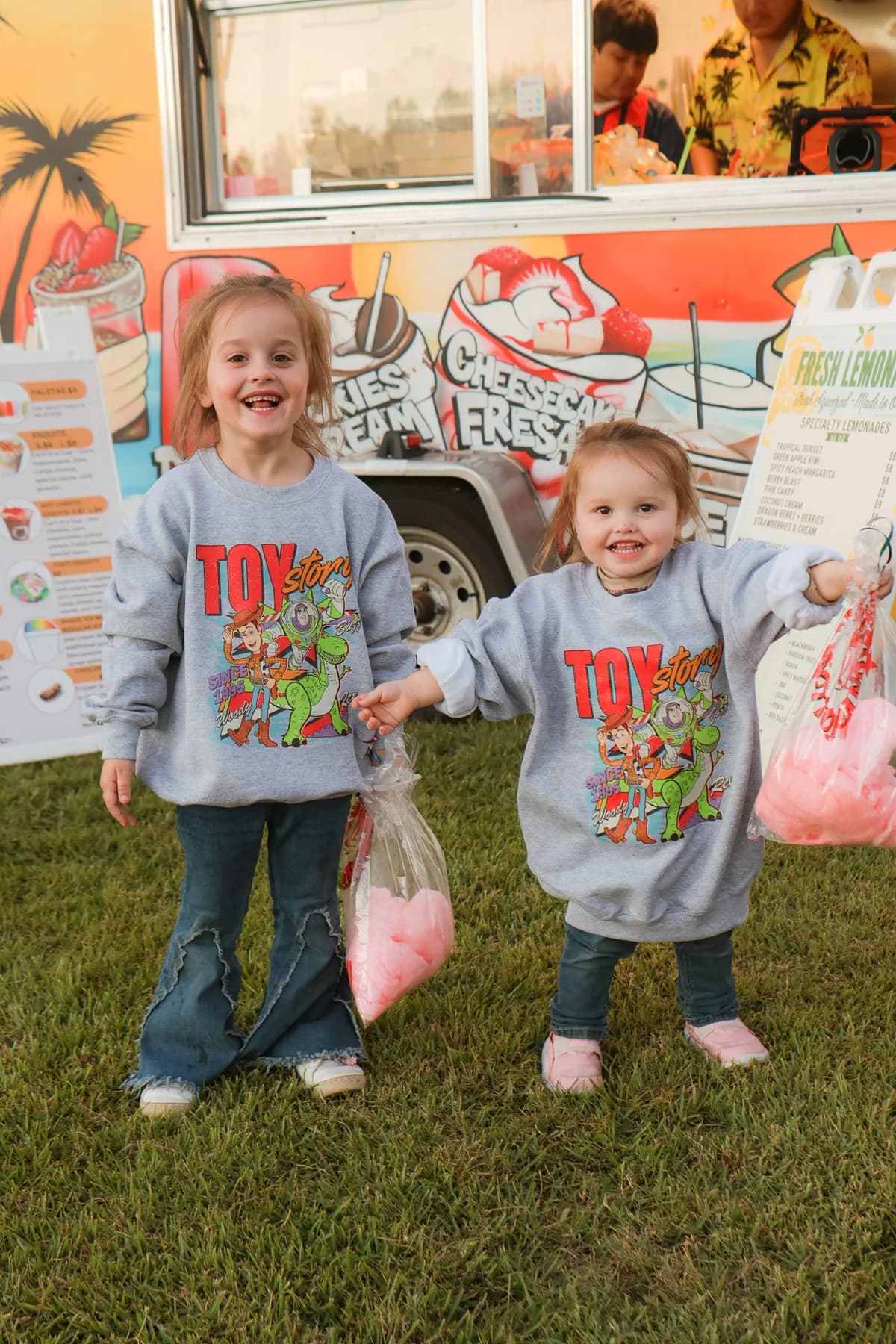 Two children enjoying treats in front of a food truck at family movie night